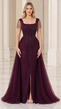 Front view of woman wearing burgundy square neck beaded evening gown with front slit and tulle overskirt