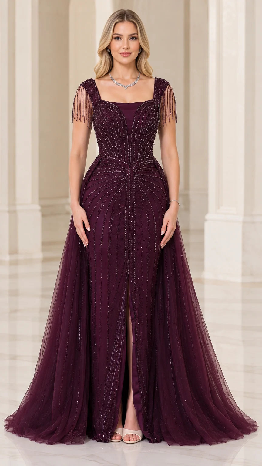 Front view of woman wearing burgundy square neck beaded evening gown with front slit and tulle overskirt