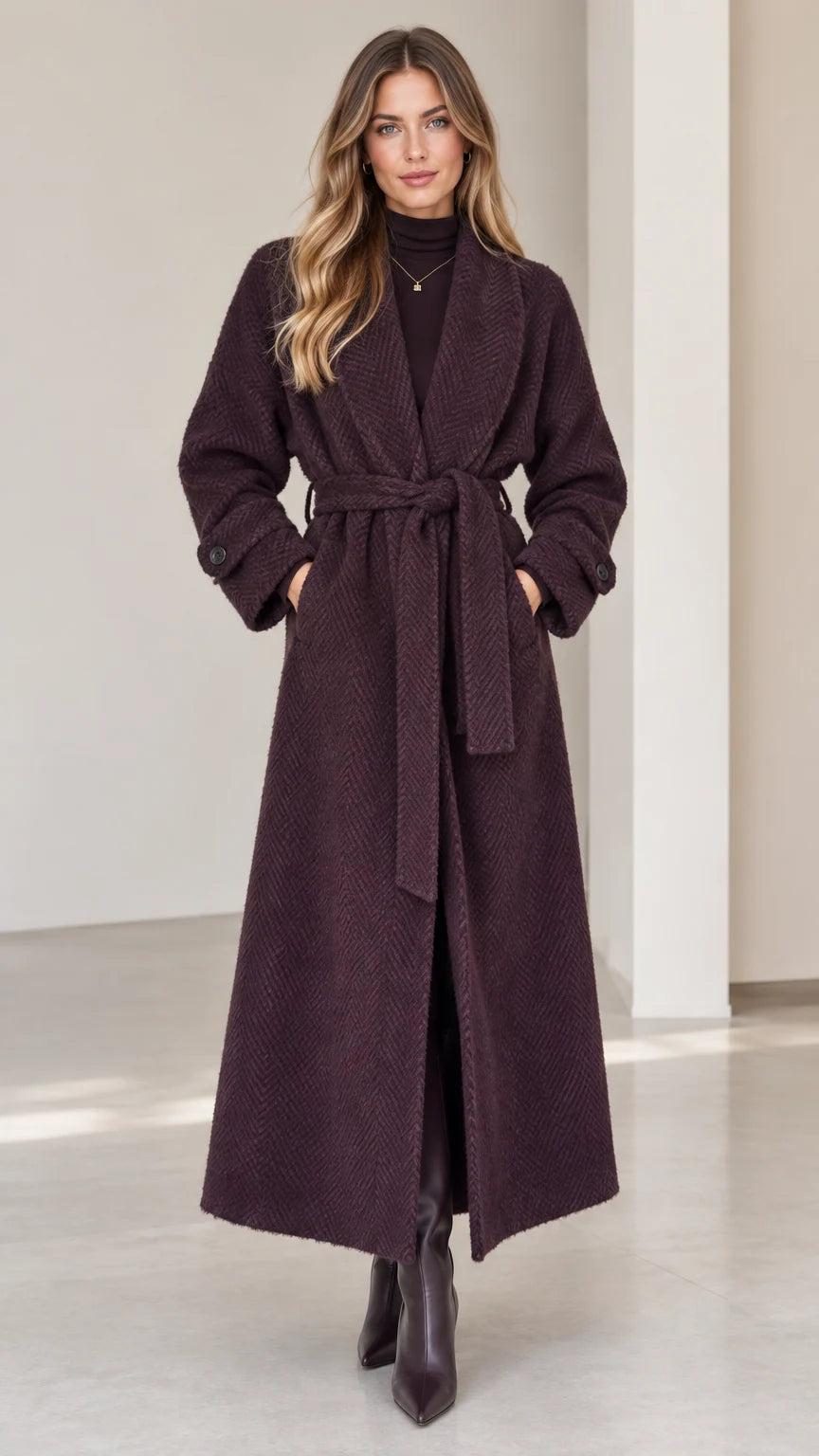 Front view of woman wearing deep plum herringbone maxi wrap coat with belt