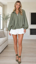 Front view of model wearing olive green zip-up bubble hem jacket with balloon sleeves