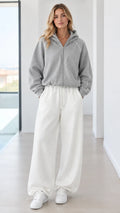 Full front view of model wearing heather grey zip hoodie and off-white wide-leg sweatpants