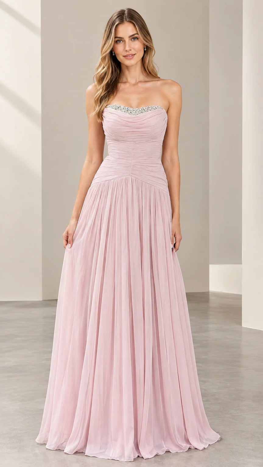 Front full view of woman wearing a strapless blush pink chiffon evening gown with beaded neckline