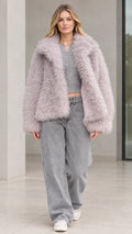 Front view of model wearing dusty lilac textured shaggy faux fur jacket with wide-leg jeans