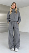 Full front view of model wearing grey plaid high-neck top and wide-leg pants set