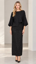 Front full-length view of woman wearing black sparkle boat neck top and maxi column skirt set