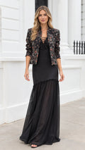Full front view of model wearing black floral jacquard cropped jacket and lace-up maxi dress set