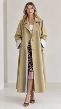 Front view of woman wearing long khaki trench coat with turned-up pinstriped cuffs