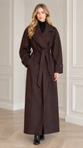 Full front view of model wearing dark brown maxi belted trench overcoat