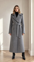 Front full-length view of woman wearing grey maxi belted trench coat