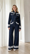 Front view of model wearing dark denim lace trim jumpsuit