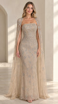 Front view of model wearing champagne beaded strapless evening gown with sheer cape