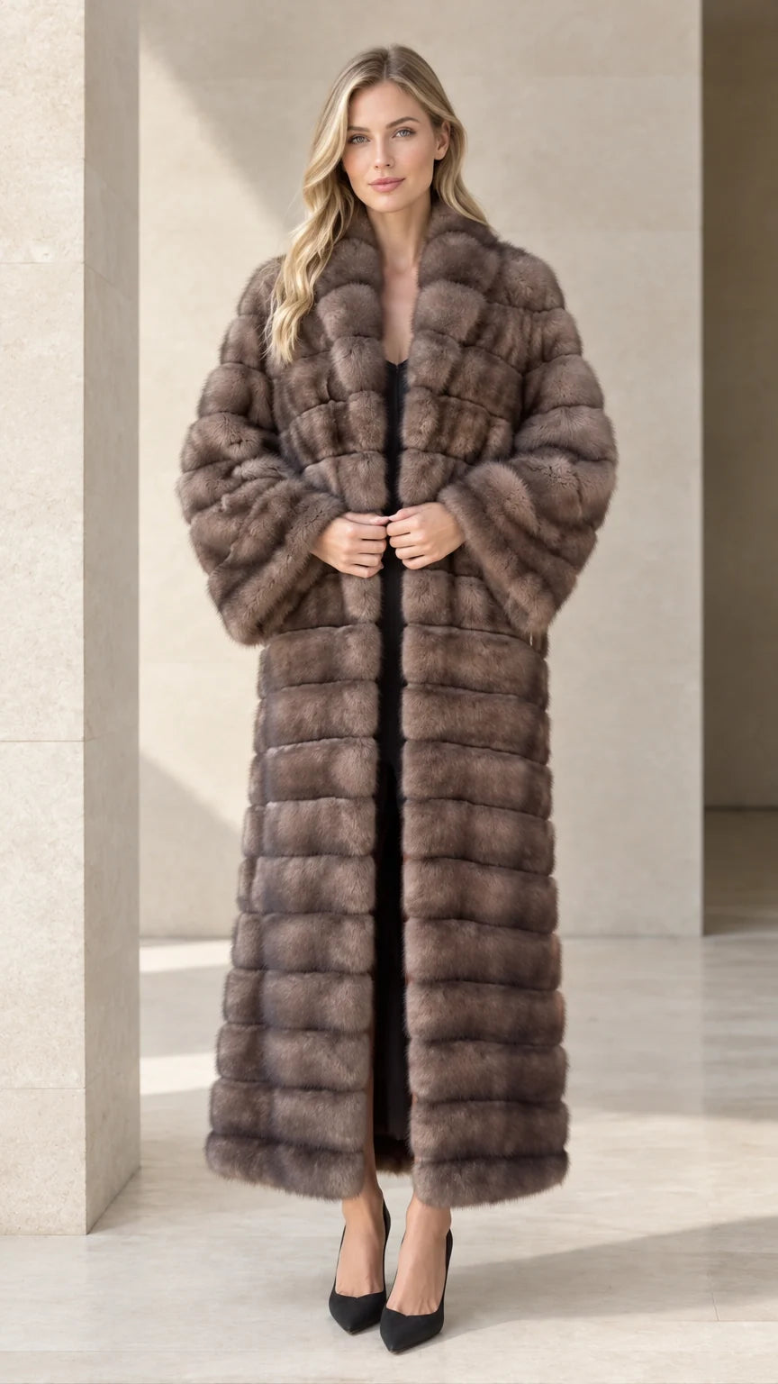Full front view of model wearing a taupe horizontal paneled faux fur maxi coat with black pumps