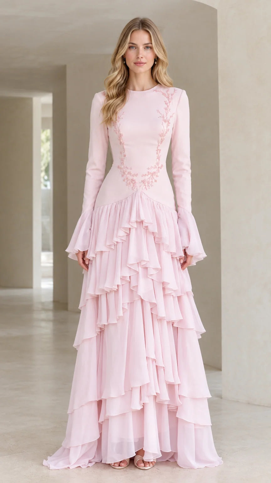 Front full-length view of woman in blush pink embroidered long sleeve tiered ruffle maxi gown