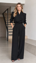 Front full view of woman wearing black tailored wrap-front wide-leg jumpsuit