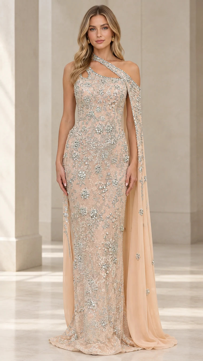Front view of model wearing champagne embellished one-shoulder lace evening gown with attached cape