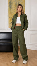 Full-body front view of woman wearing olive green bomber jacket and wide-leg pants set
