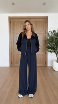 Front view of model wearing navy blue contrast collar zip jacket and wide leg pants set