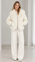 Front full view of woman wearing cream zip-up bomber jacket with oversized faux-fur collar and matching wide-leg pants