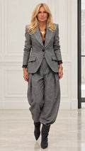 Model wearing Grey herringbone blazer and pleated balloon trousers two-piece suit set with lace cuffs