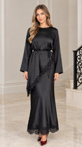 Front full-length view of woman wearing black satin maxi dress with lace trim and tie waist