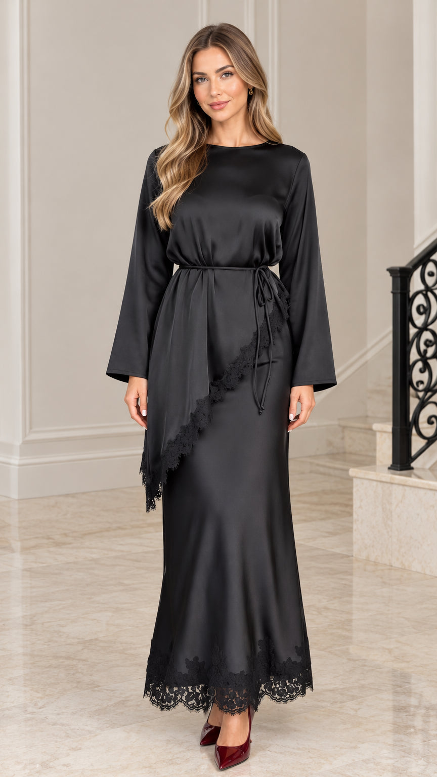 Front full-length view of woman wearing black satin maxi dress with lace trim and tie waist