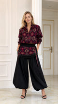 Front full view of woman wearing burgundy geometric print blouse and black balloon pants set