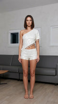 Model wearing white one-shoulder sequin crop top and shorts set, front view