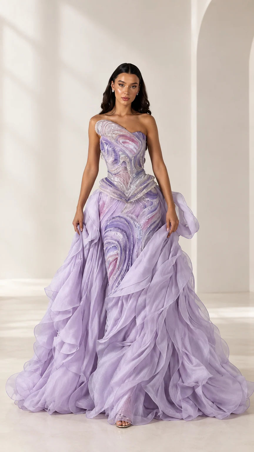 Front full-length view of model wearing lavender one-shoulder embellished ruffle formal gown