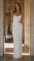 Front view of model wearing white strapless corset peplum sequin maxi dress with crystal brooch
