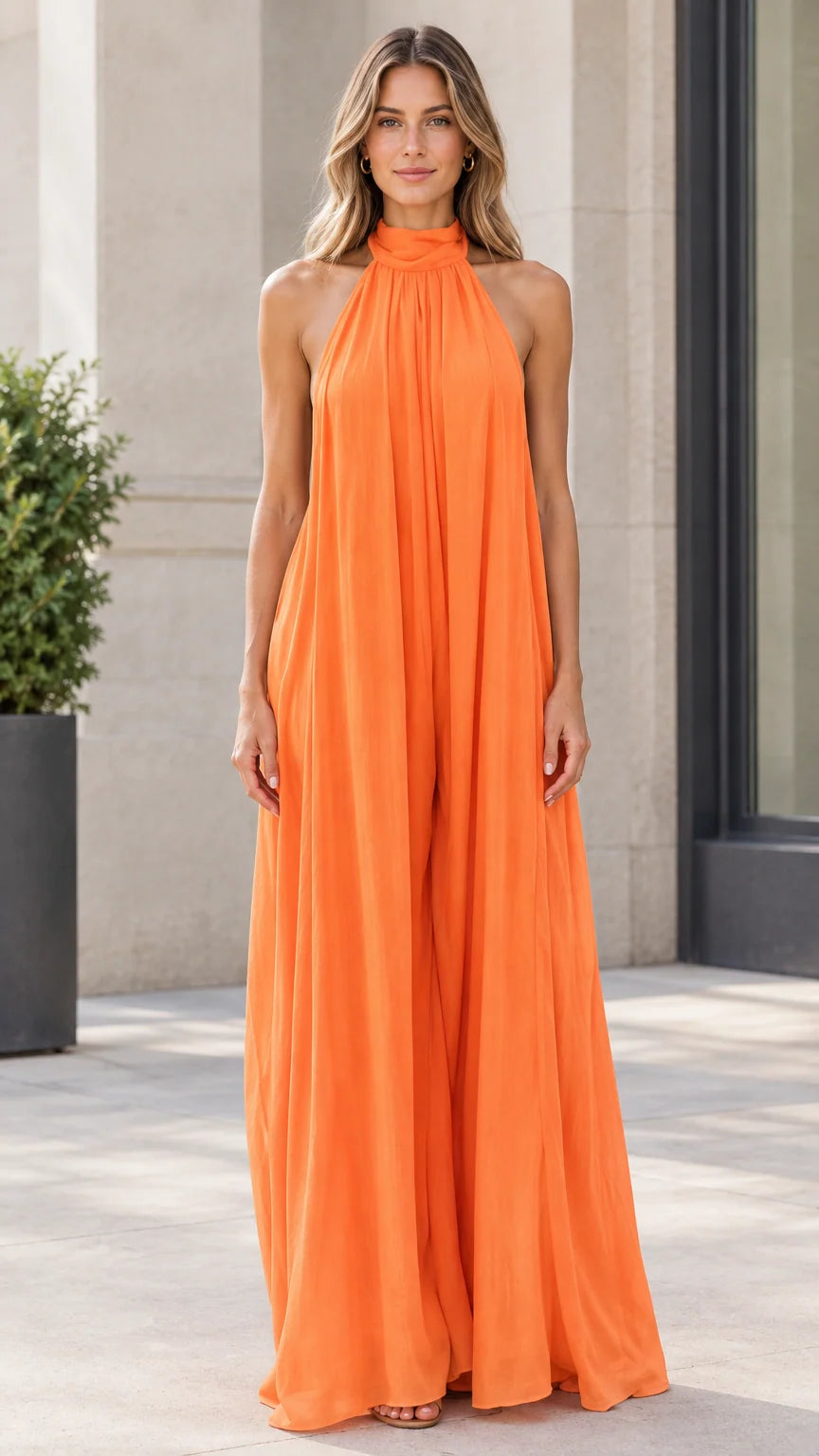 Front view of model wearing bright orange halter neck wide-leg flowy jumpsuit
