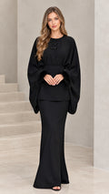 Full front view of model wearing black feather-cuff batwing tunic and maxi skirt set