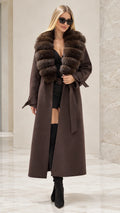 Front full view of woman wearing brown maxi trench coat with faux fur collar and belt