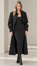 Full front view of women's long black maxi trench coat worn over black bodycon dress