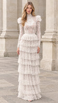Front full-length view of model wearing ivory high-neck tiered lace maxi dress with puff shoulders
