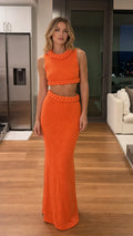 Front view of model wearing vibrant orange braided trim knit crop top and maxi skirt set