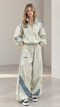 Front view of woman wearing sage green retro two-piece windbreaker tracksuit set