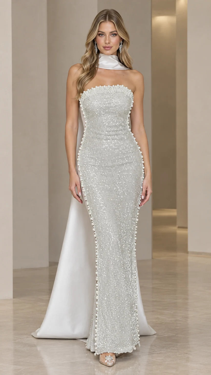 Front view of model wearing silver strapless beaded evening gown with matching neck scarf cape