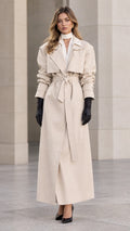 Front full-length view of woman wearing elegant cream maxi belted trench coat