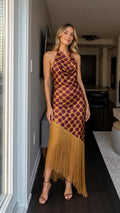 Front view of woman wearing brown polka dot halter maxi dress with fringe hem
