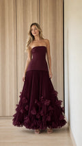 Front view of woman wearing burgundy strapless pleated ruffle evening gown