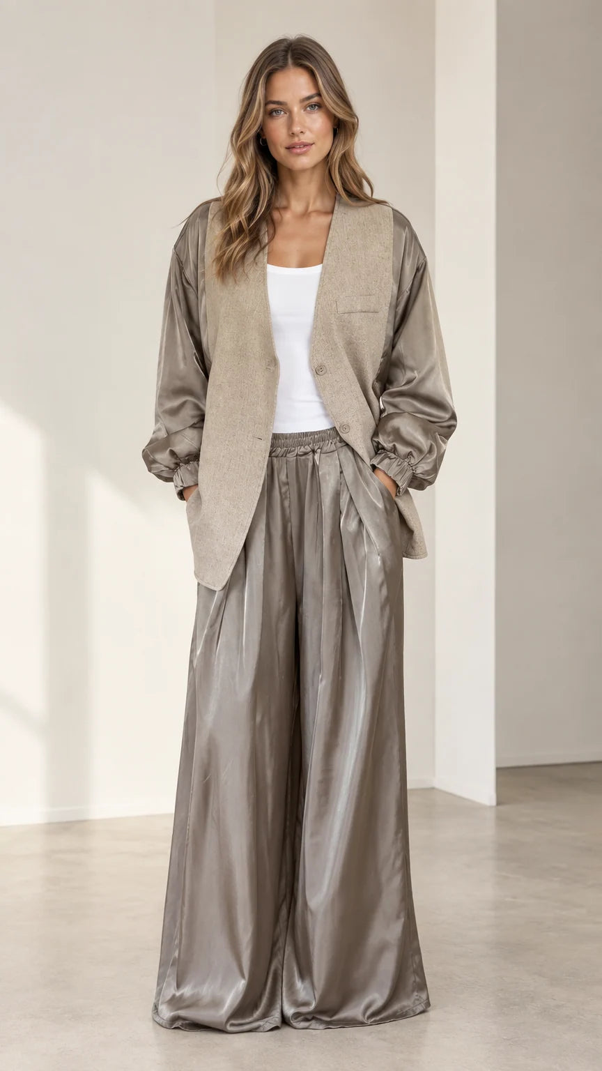 Front view of model wearing taupe textured blazer with satin balloon sleeves and matching wide-leg trousers