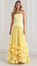 Front view of model wearing yellow strapless drop-waist corset maxi dress with 3D floral hem