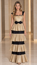 Full front view of Champagne Gold pleated tiered maxi evening dress with black lace trim and waist bow