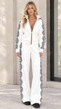 Front view of model wearing white two-piece tracksuit set with black lace side trim