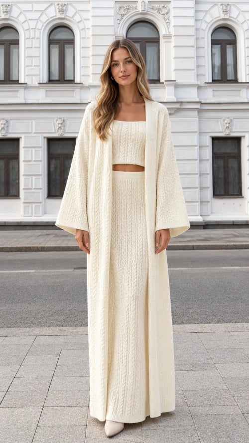 Front full-length view of woman wearing cream 3-piece cable knit duster, crop top, and skirt set
