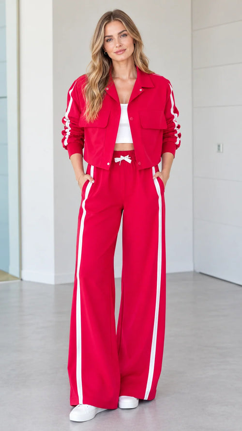 Front full view of woman wearing red 2-piece side stripe cropped jacket and wide-leg track pants set