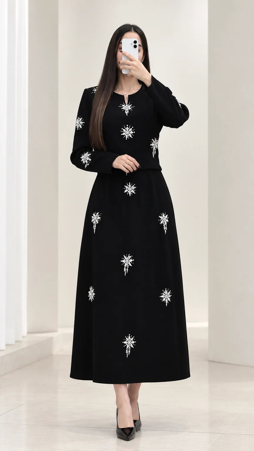 Front view of black rhinestone embellished long sleeve top and maxi skirt set