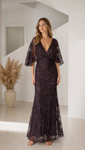 Front view of woman wearing dark plum floral sequin flutter sleeve maxi evening dress
