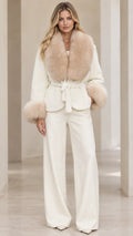 Front full view of woman wearing cream belted jacket with faux fur trim and wide leg pants