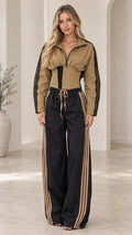 Front view of woman wearing camel and black corset tracksuit set with side stripes